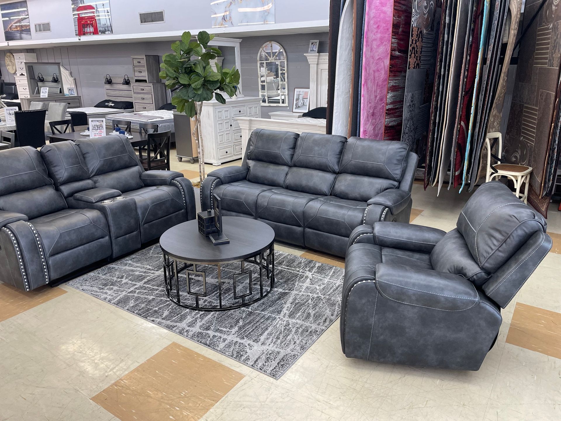 Grey leather living room set with rug and coffee table in a furniture store. Bayou furniture New Orleans