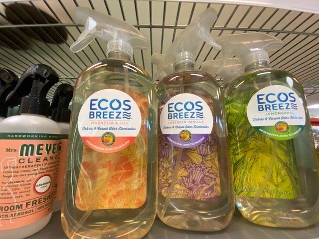 Three bottles of ecos breeze are sitting on a shelf.