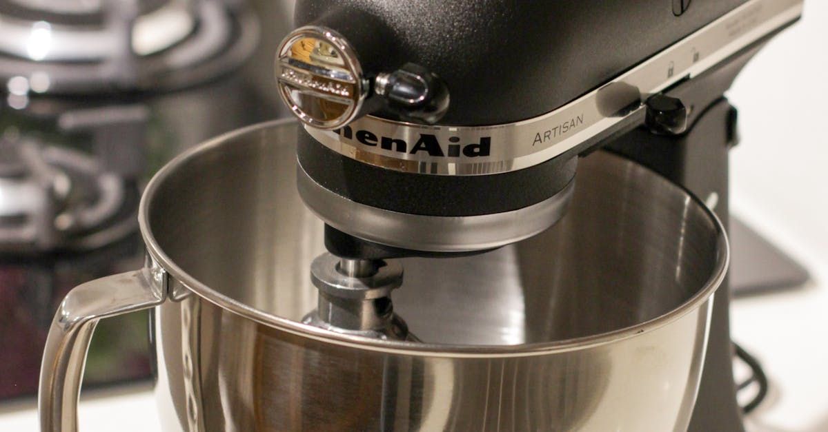 A black kitchenaid mixer with a stainless steel bowl