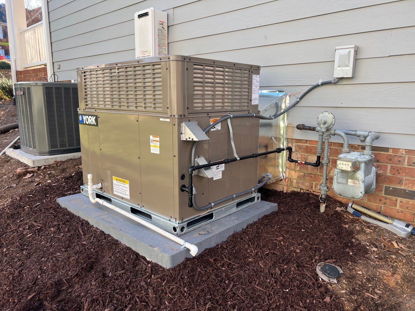 A large air conditioner is sitting on the side of a house.