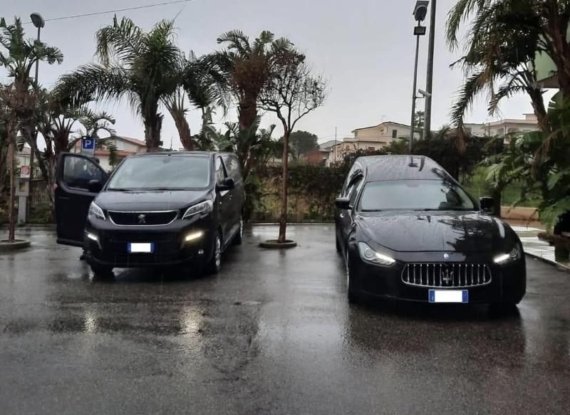 Persone che esaminano documenti e computer portatili attorno a un tavolo.