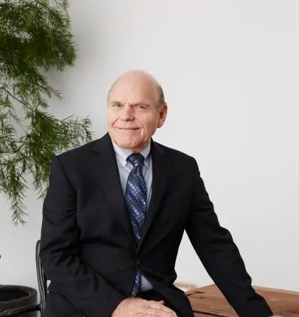 A man in a suit and tie is sitting on a bench