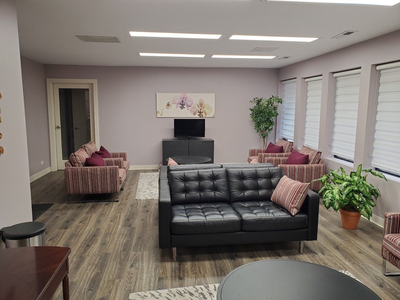 A living room with a couch , chairs , and a television.