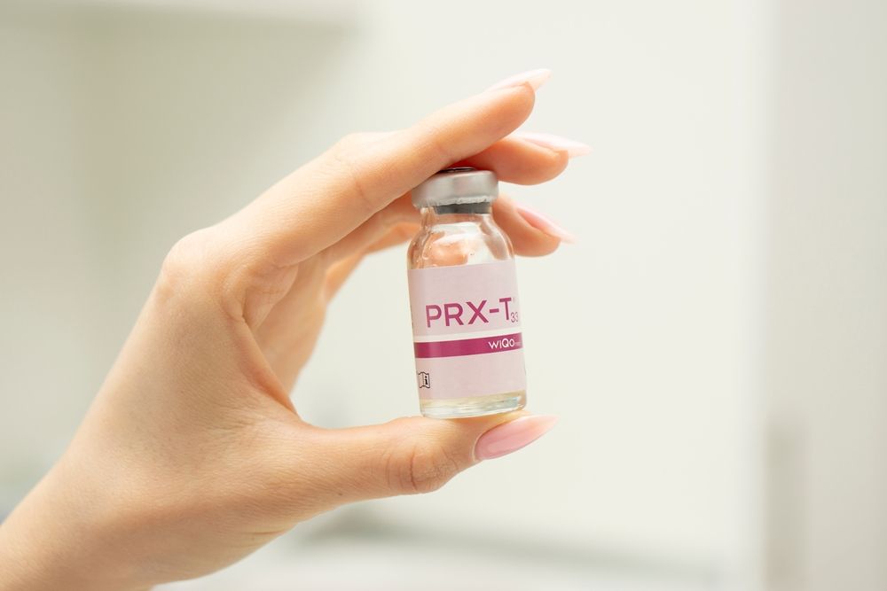 A woman is holding a bottle of prx-t in her hand.