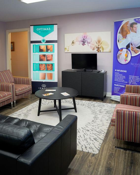 A living room with a couch , chairs , table and television.