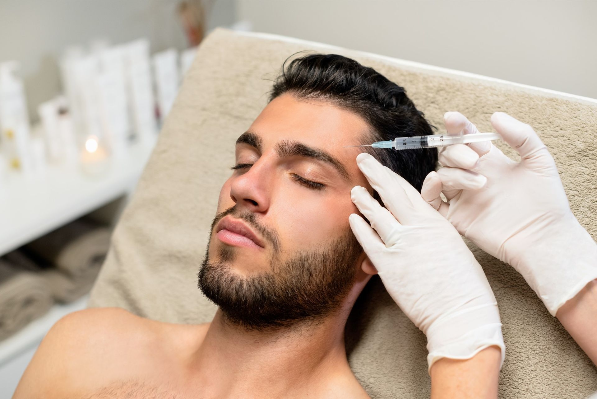 A man is getting a botox injection in his forehead.