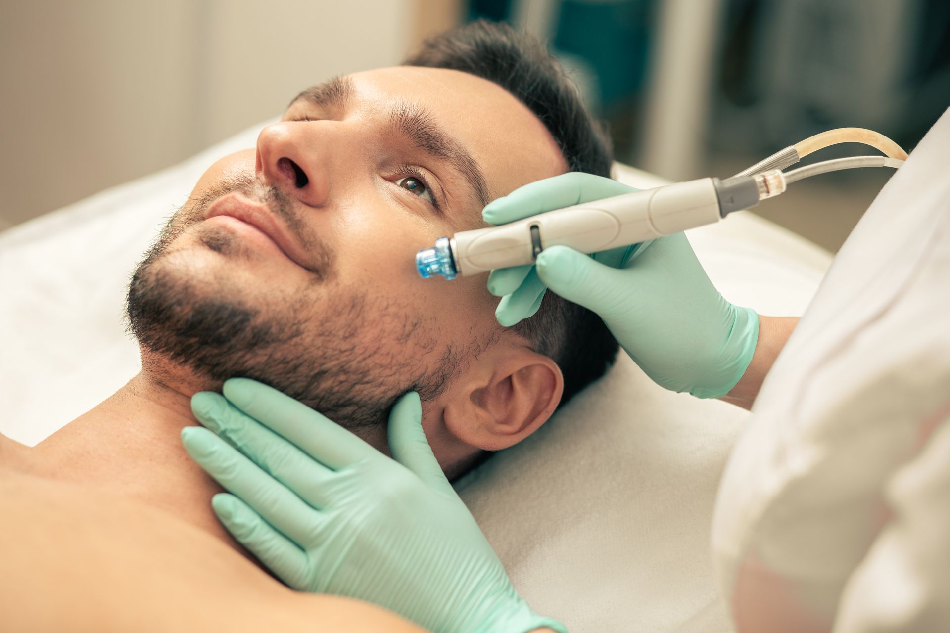 A man is getting a facial treatment at a beauty salon.