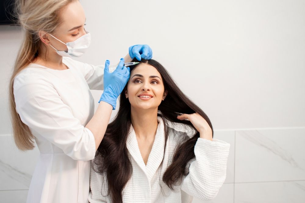 A woman is getting her hair cut by a hairdresser in a salon.