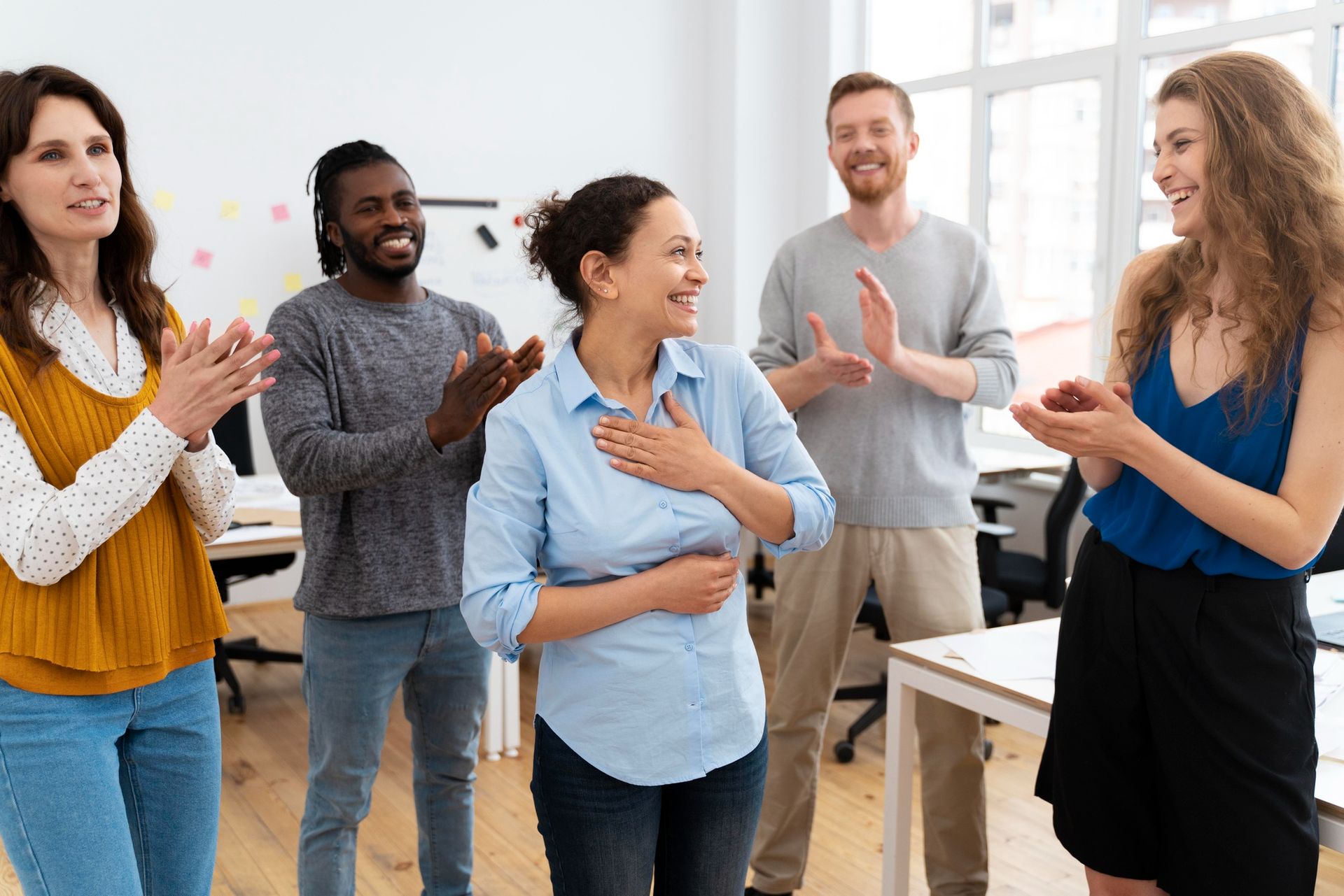 A group of people are clapping their hands in an office.