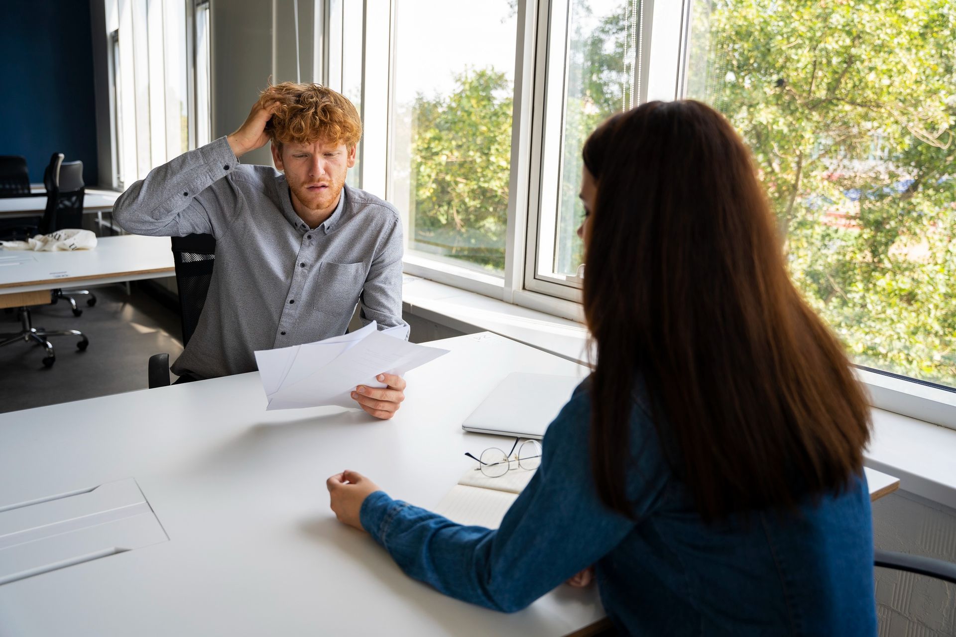 A man and a woman are sitting at a table having a job interview.