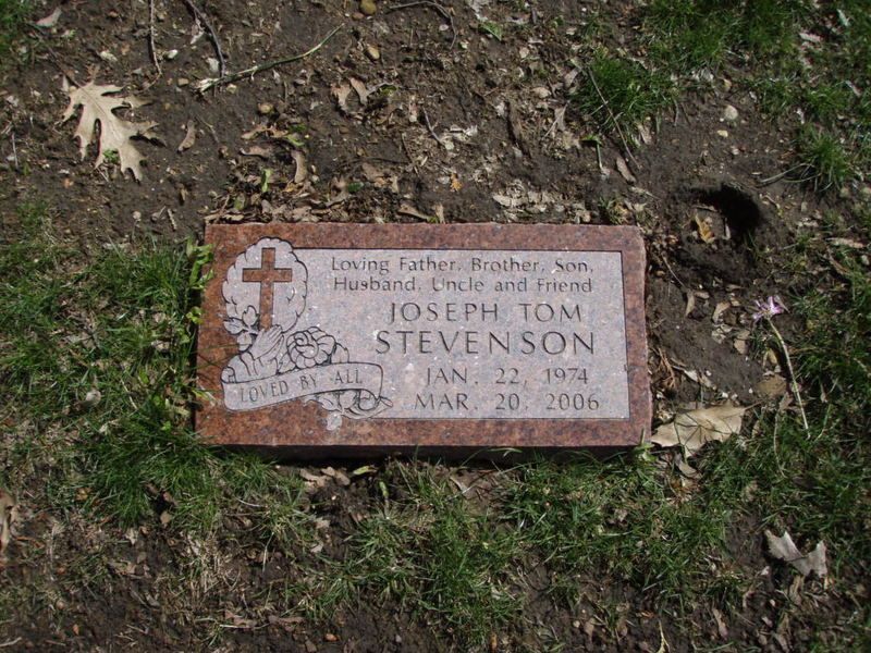 Gravestone of Joseph Tom Stevenson, red granite, with dates 1974-2006, in a grassy area.