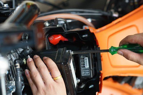 mani con chiave inglese mentre riparano la batteria di un auto