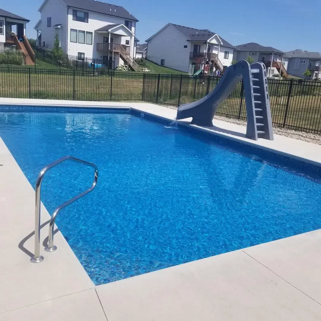 A large swimming pool with a slide and stairs
