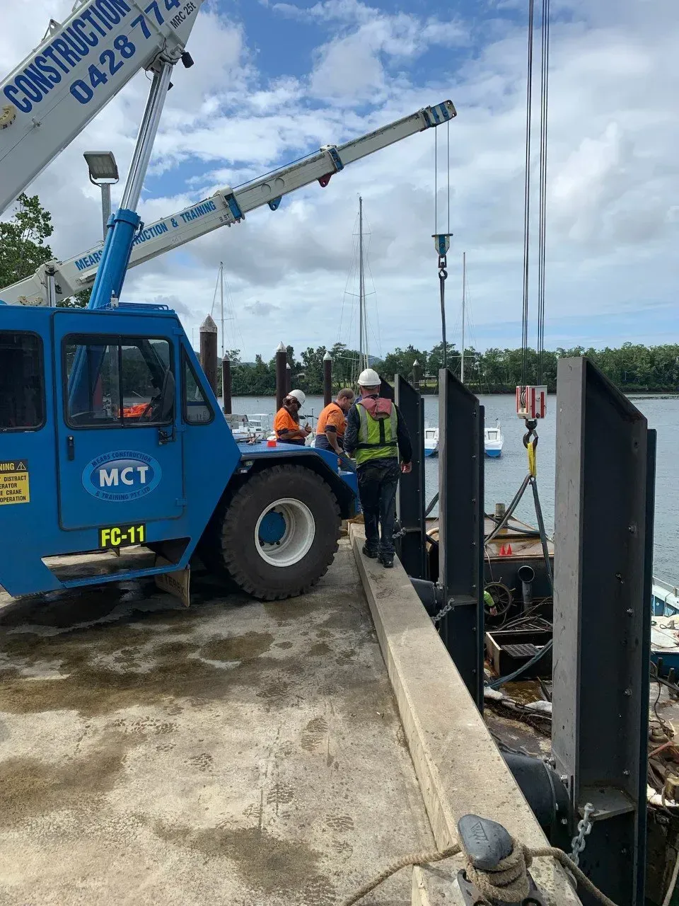 Construction Workers On A Dock Near A Blue Crane — Mears Construction & Training Pty Ltd in South Johnstone, QLD