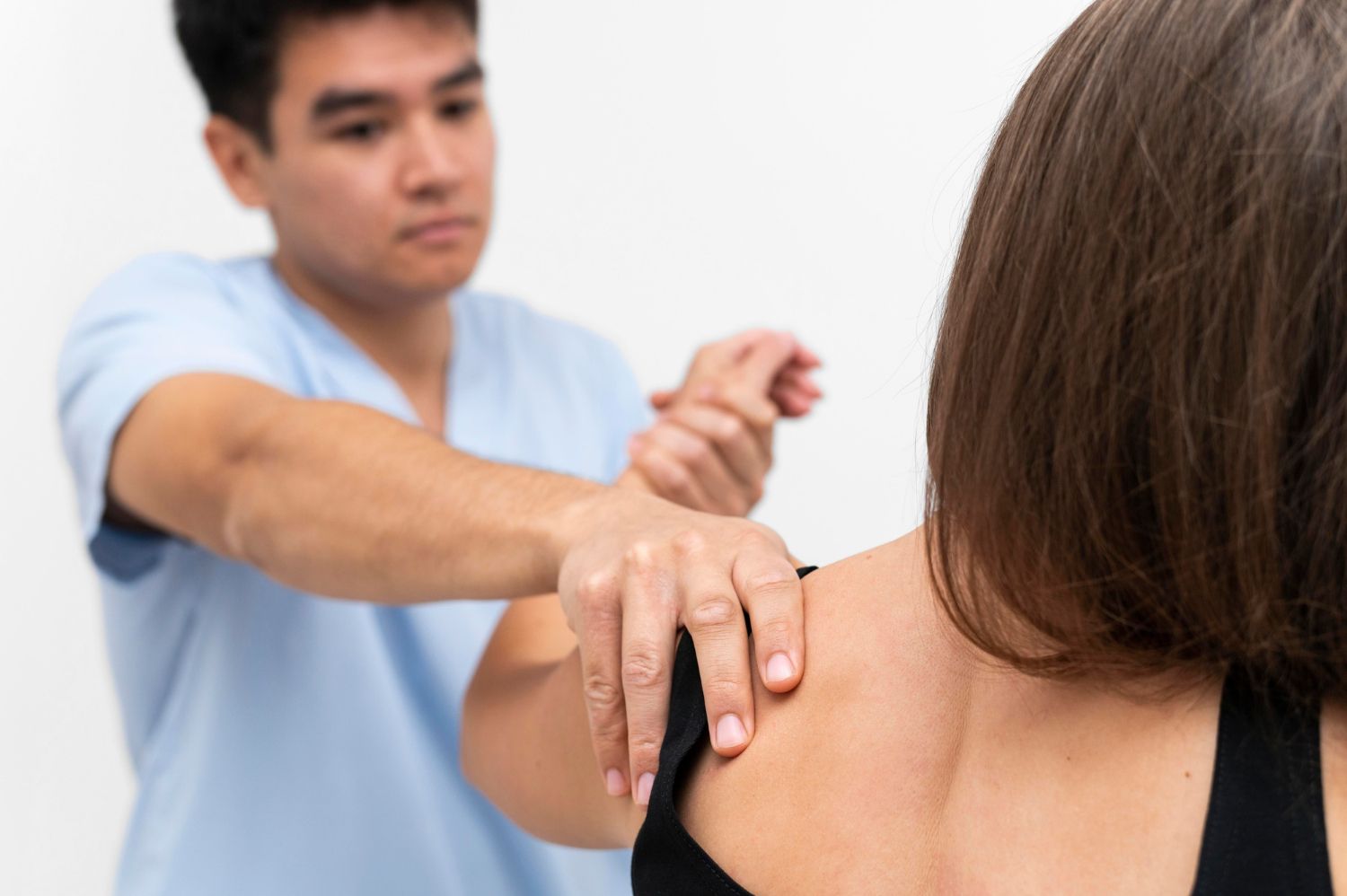 A man is giving a woman a massage on her shoulder.