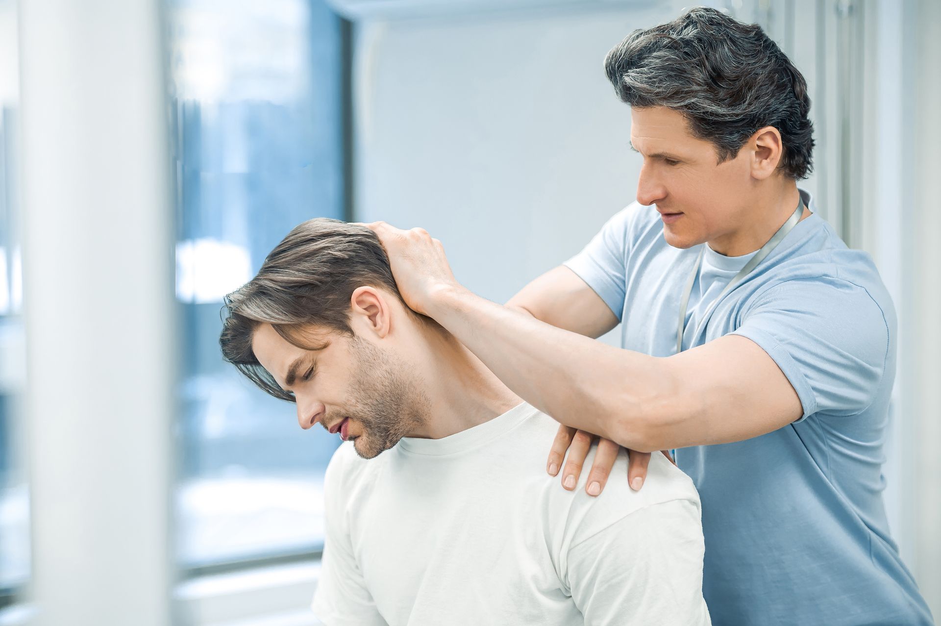 A man is getting a neck massage from a doctor.