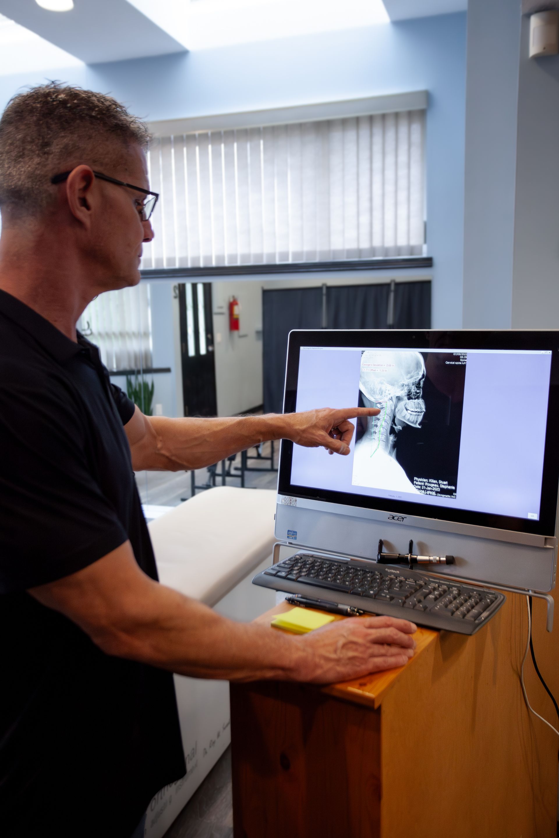 A man is pointing at an x-ray on a computer screen.