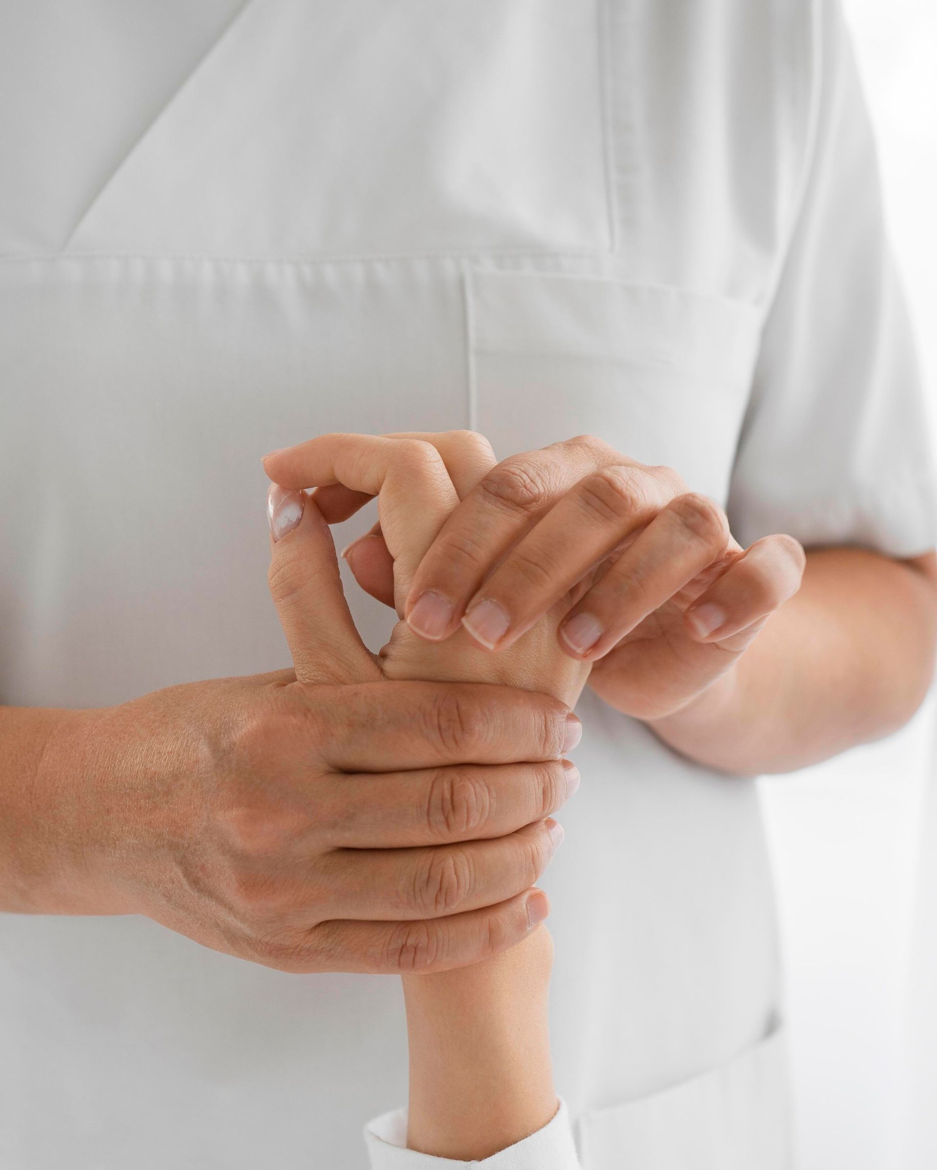 A nurse is holding a child 's hand in her arms.