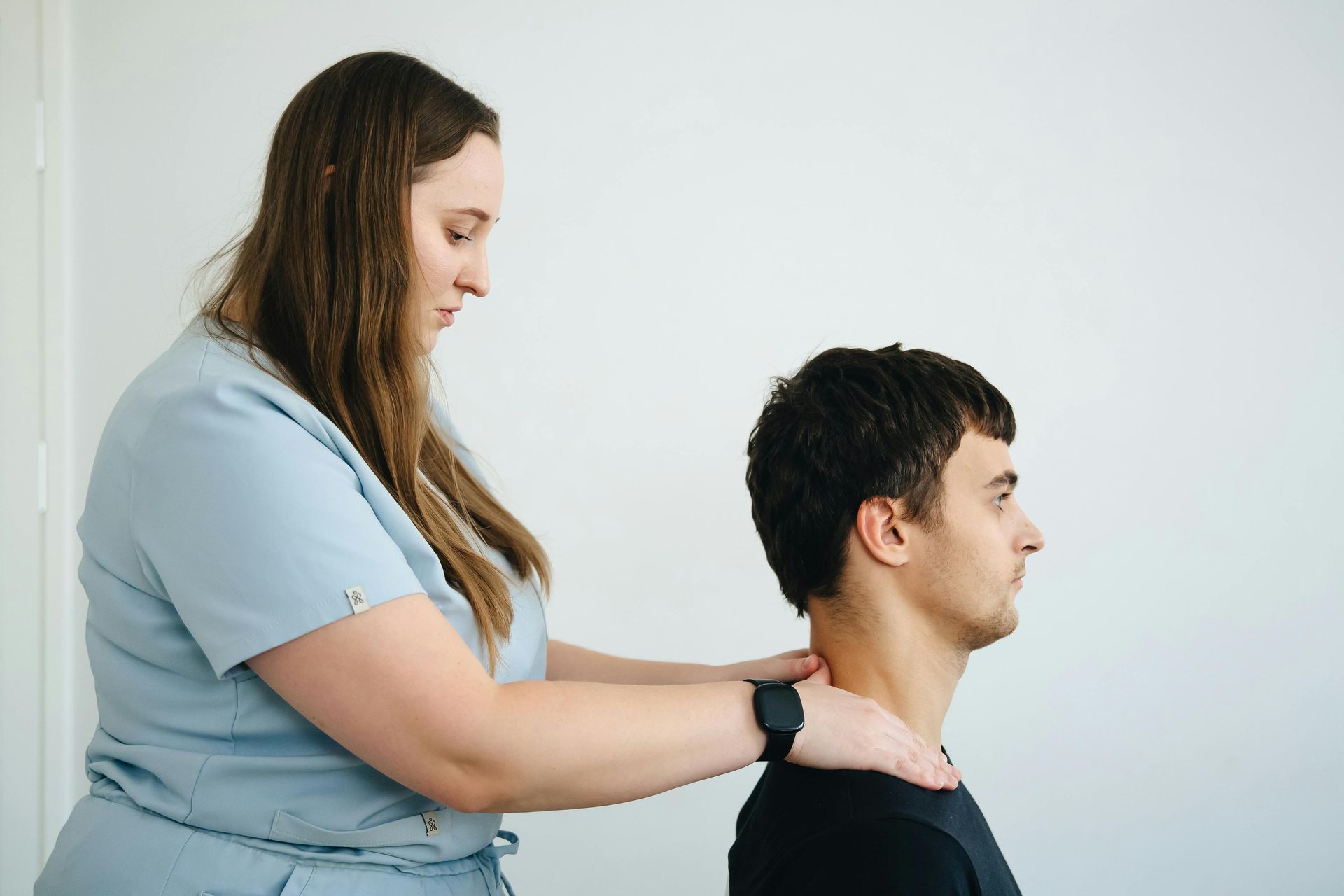 A woman is giving a man a massage on his neck.