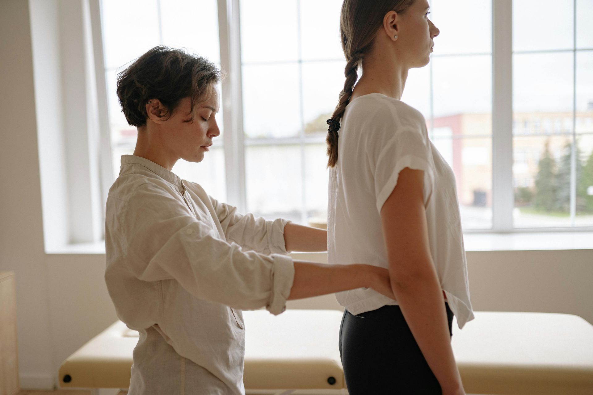 A woman is giving a woman a massage in a room.