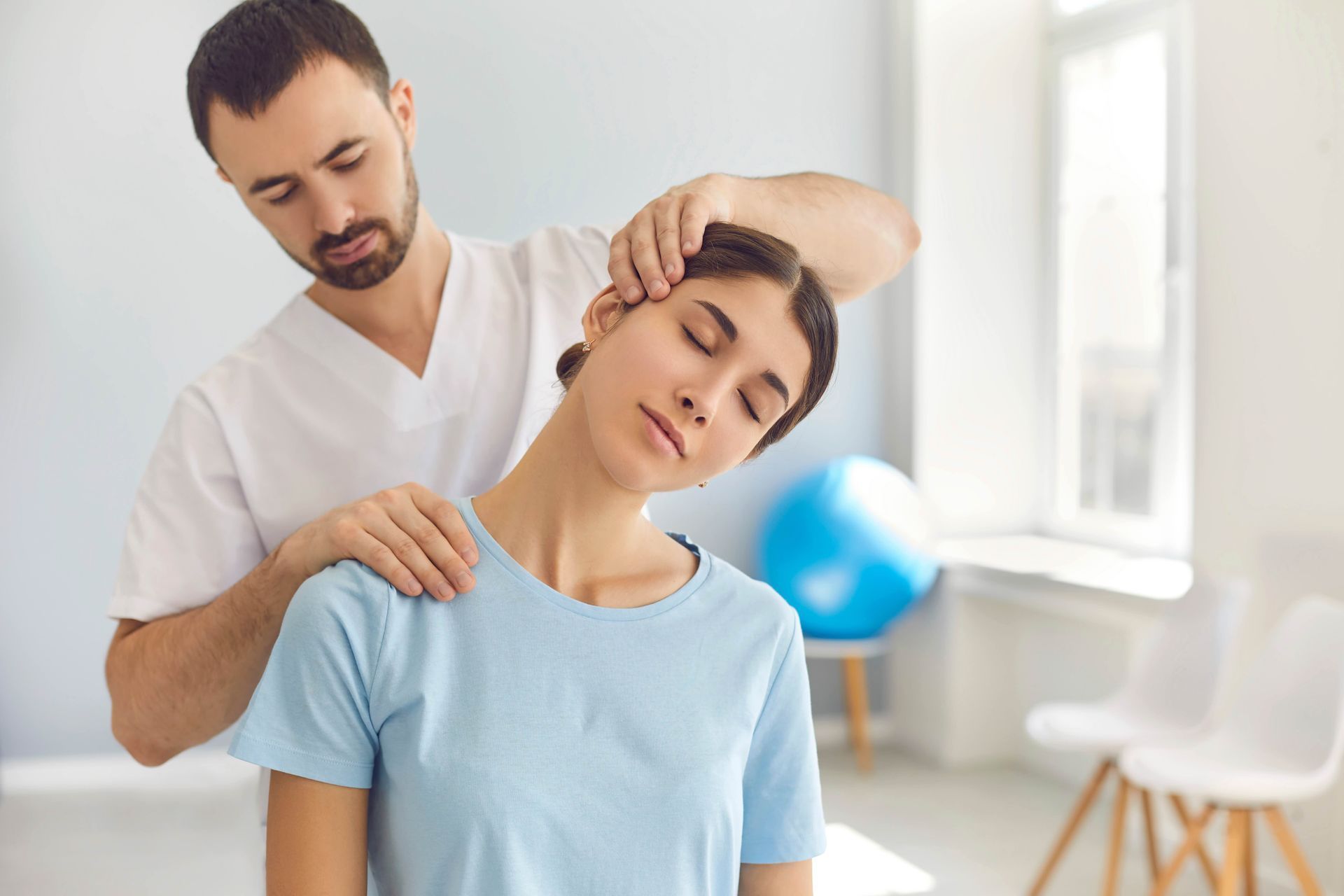 A man is giving a woman a neck massage in a room.