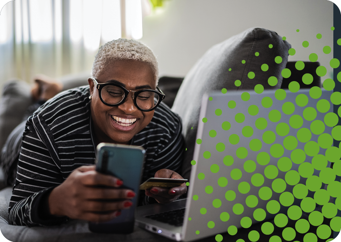 A woman smiles as she makes an online payment with her smartphone