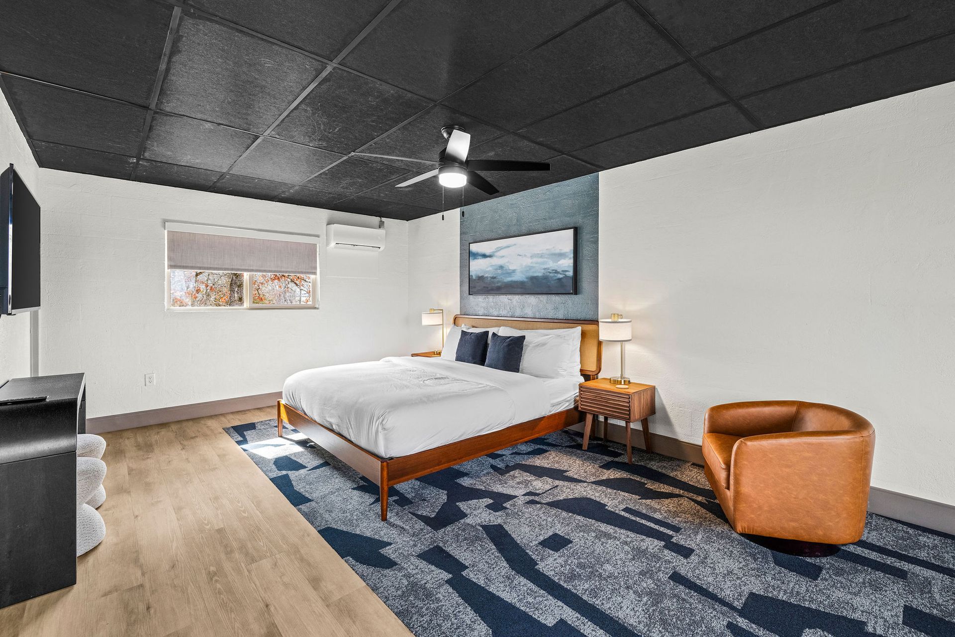 A bedroom with a large bed , chair and rug.