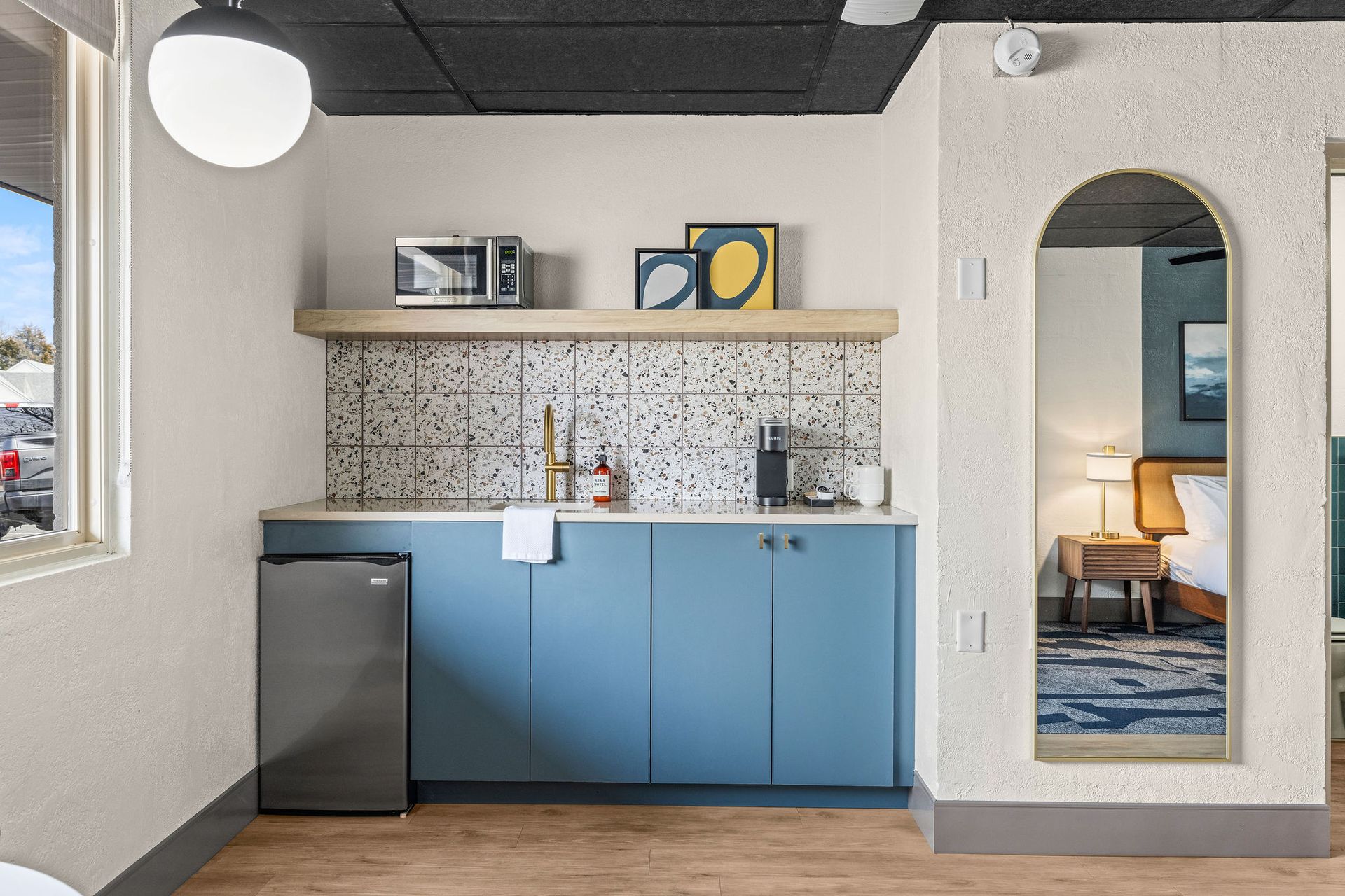 A bathroom with blue tiles and a toilet