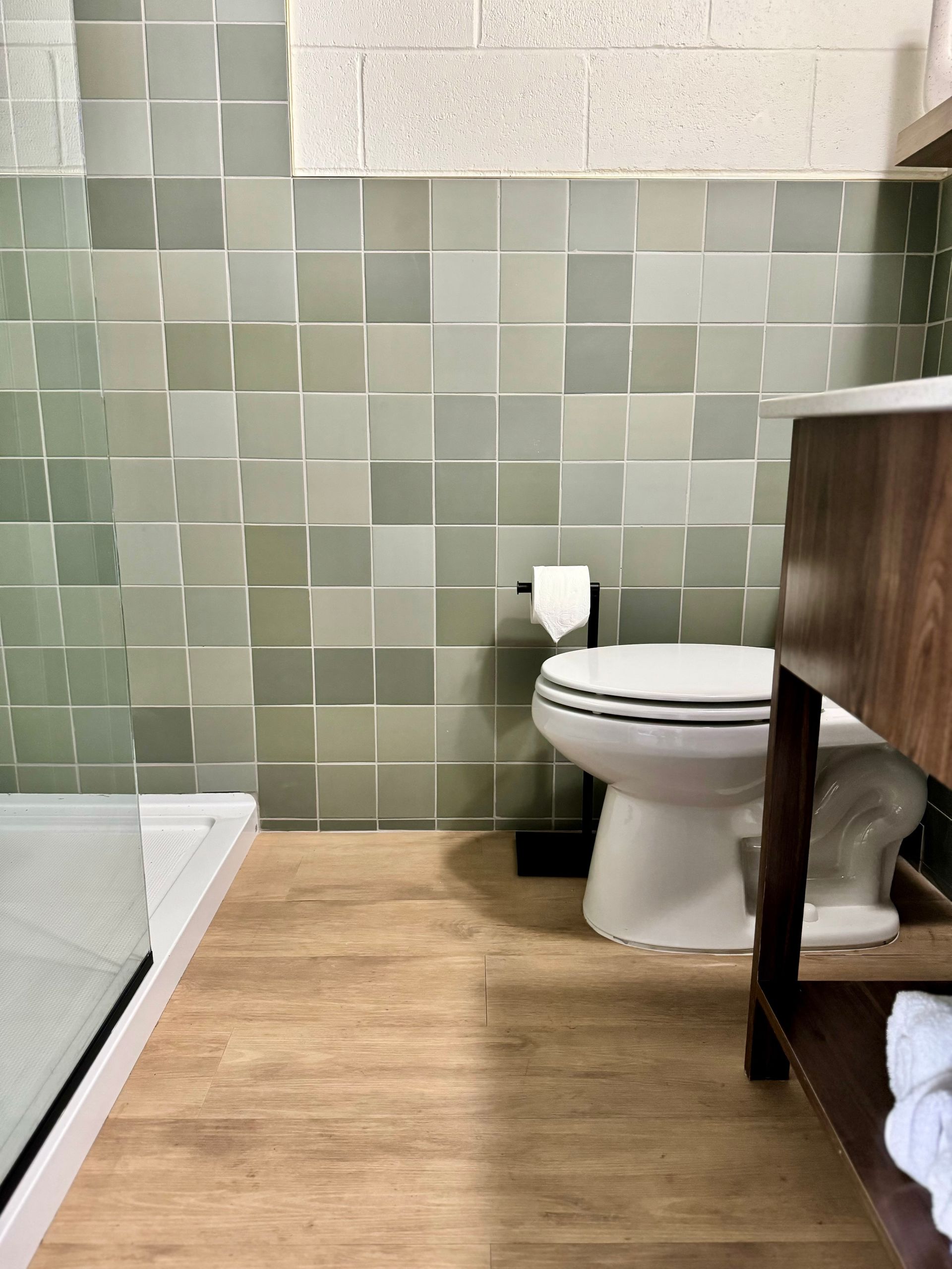 A bathroom with a toilet , sink and shower.
