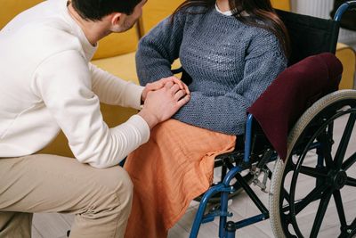 Disability support worker holding hands with a client in a wheelchair