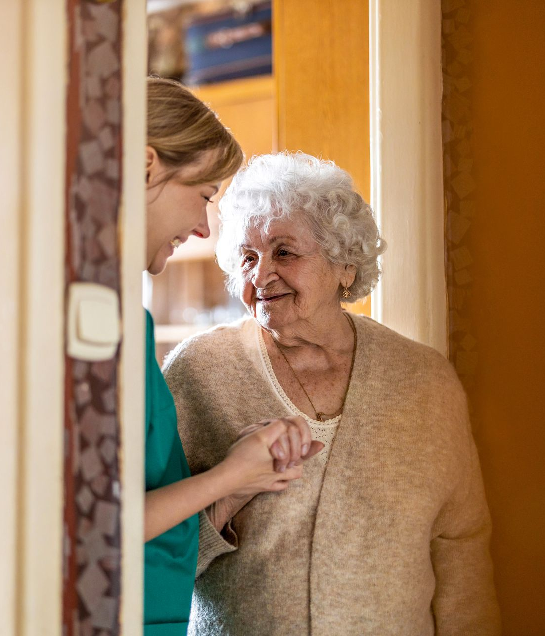 Elderly woman laughing while receiving personal care at home
