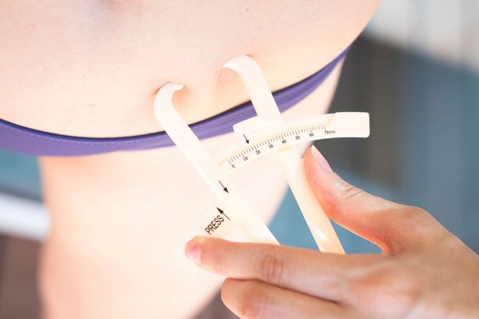 Abrochar a mano el broche de un sujetador blanco detrás de la espalda de una persona