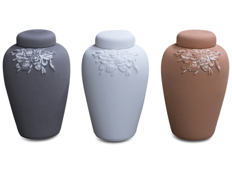 Three urns: gray, white, and brown. Each has a floral design and lid.
