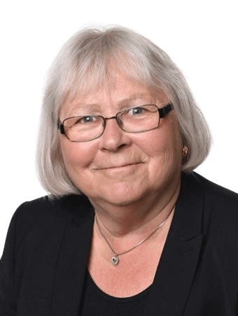 Woman with short gray hair, glasses, and black blazer smiling at camera.