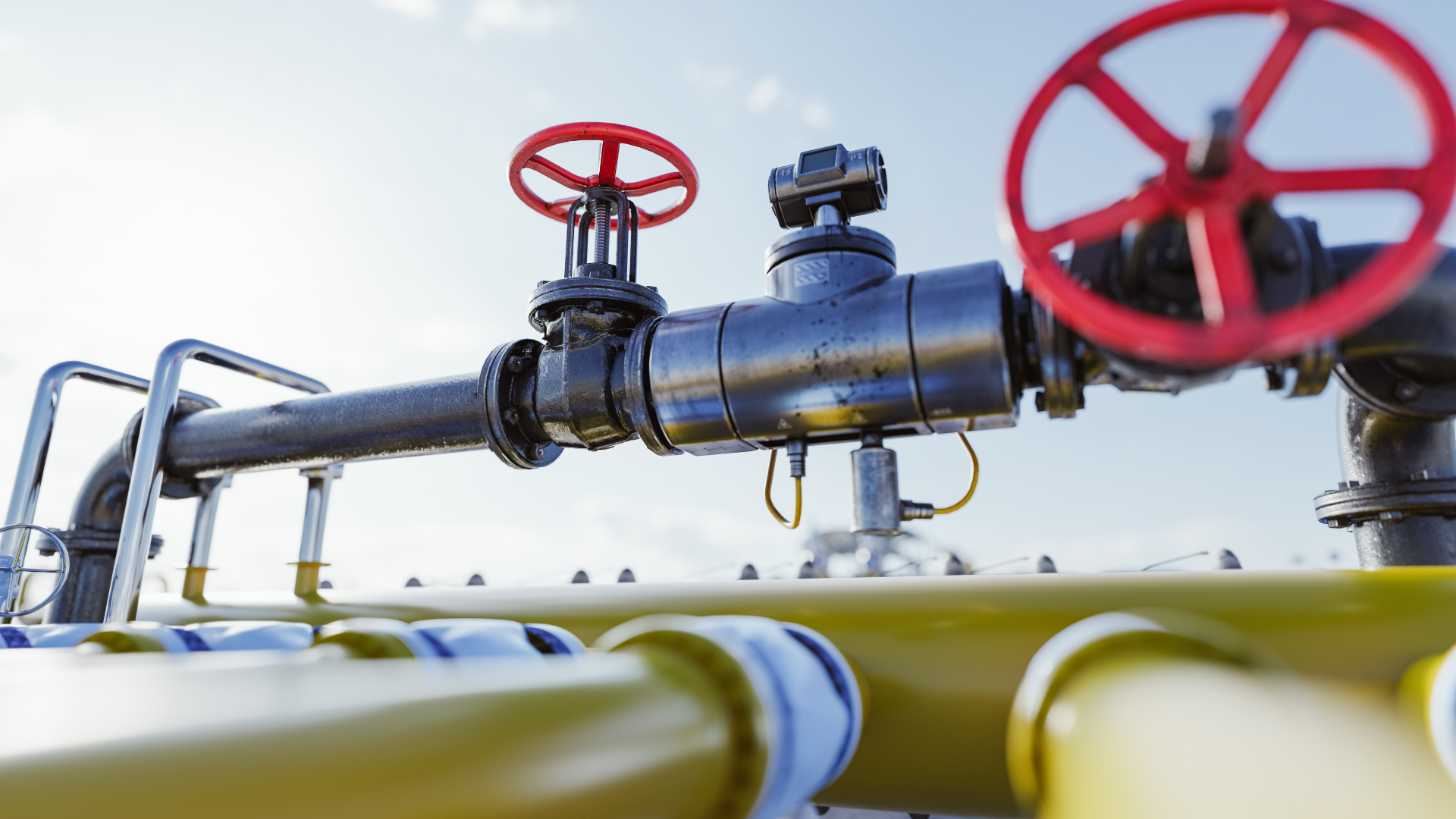 A close up of a gas pipe with red valves on it.