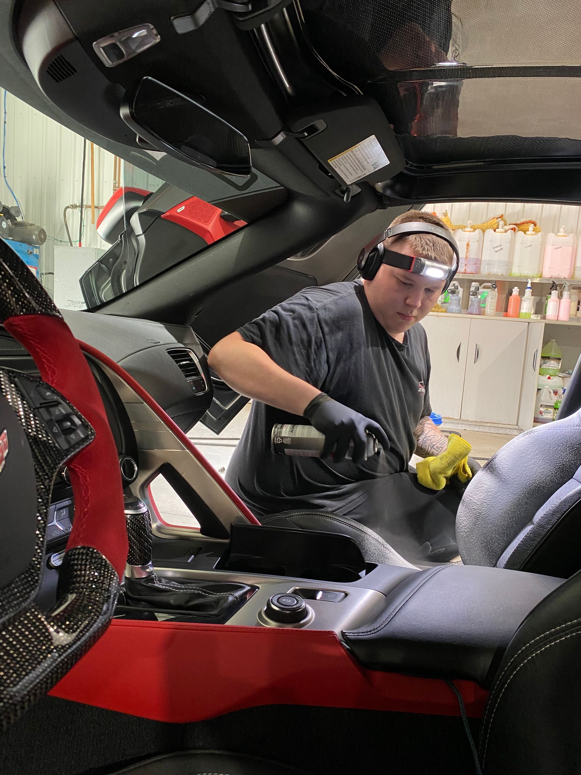 A man is working on the windshield of a car.