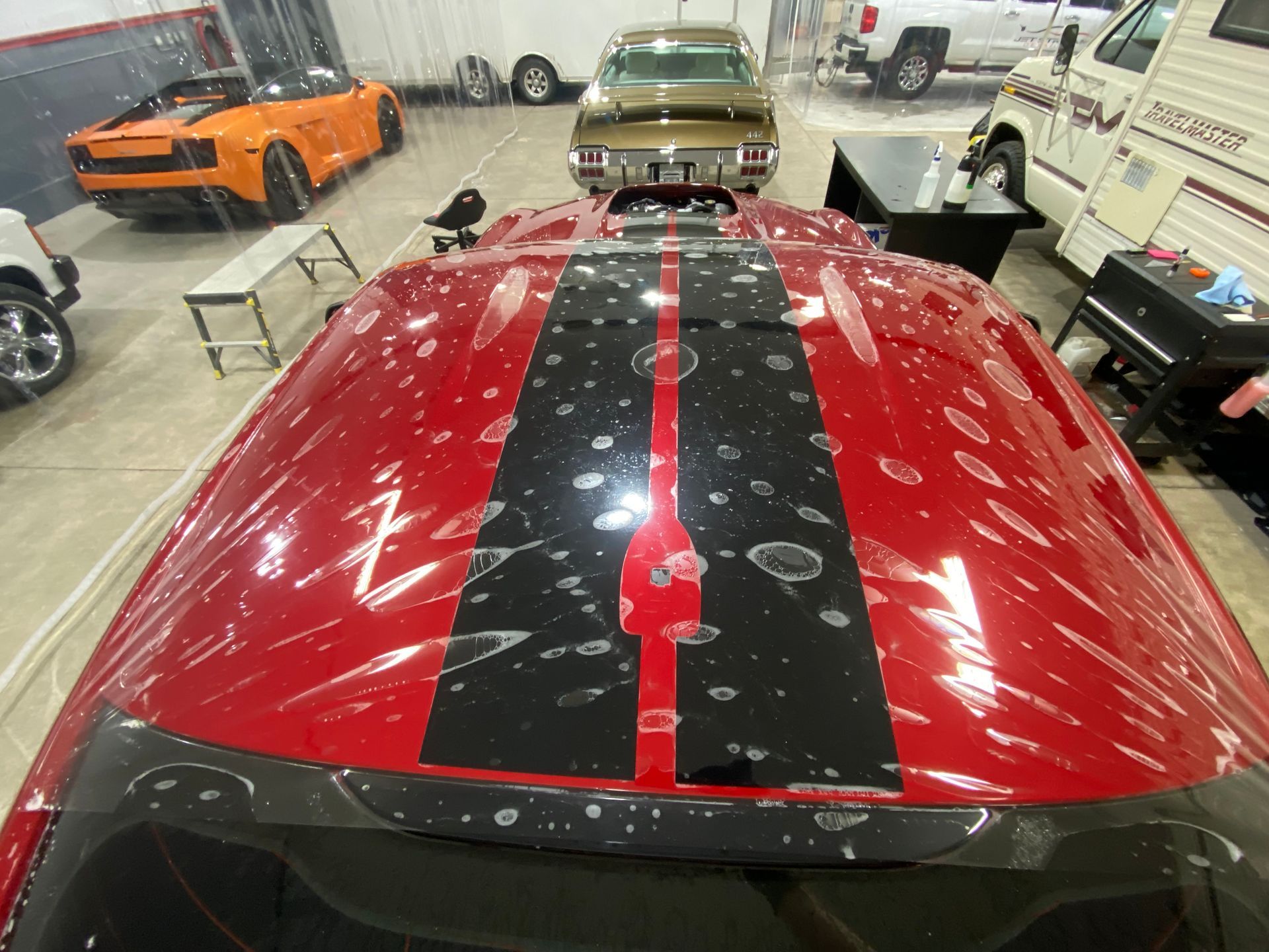 A man is applying a protective film to the side mirror of a car.