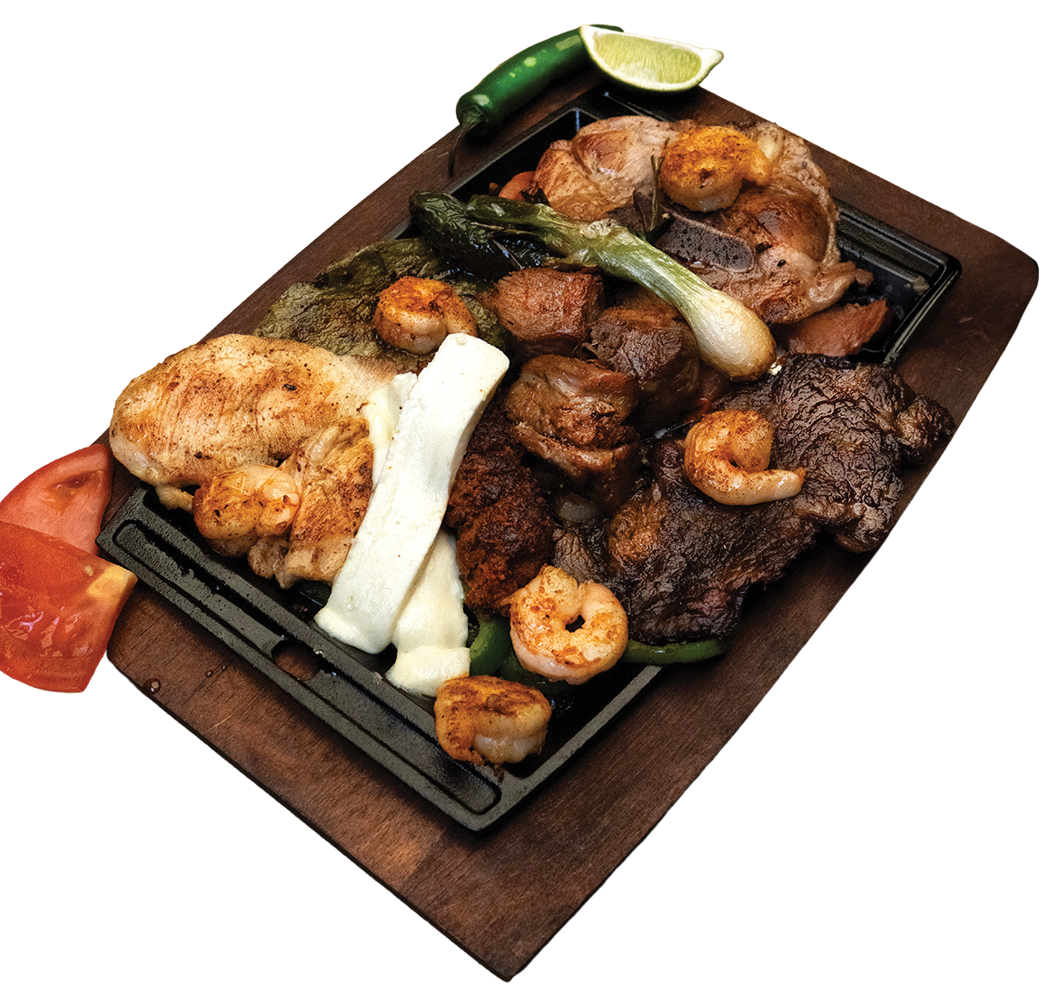 Sizzling platter of various grilled meats and shrimp, served with vegetables, cheese, and a lime.