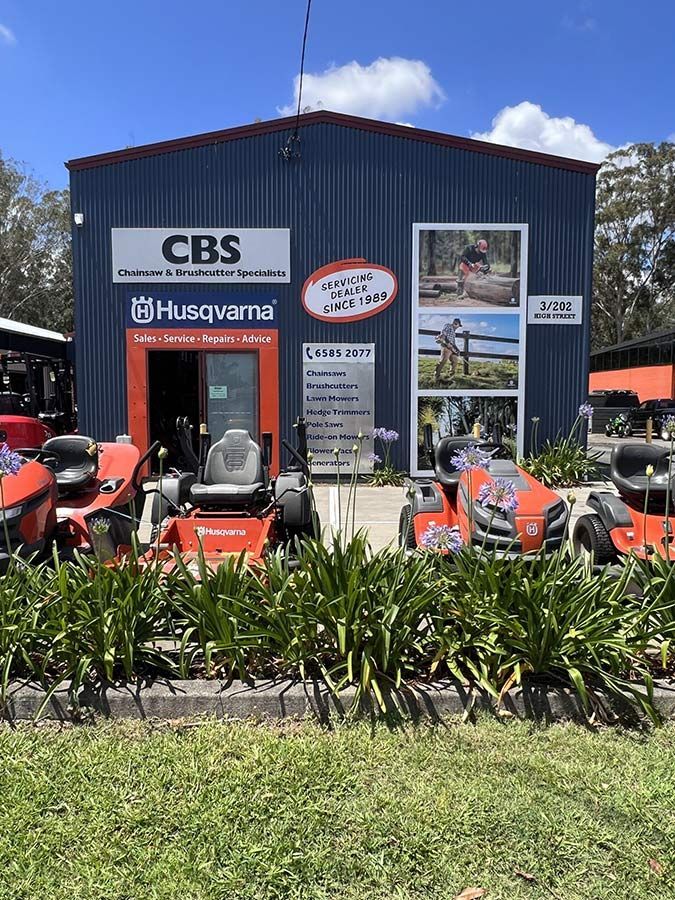 A Husqvarna Lawn Mower Is Parked in Front of A Building — CBS Chainsaw & Brushcutter Specialists - HUSQVARNA in Wauchope, NSW