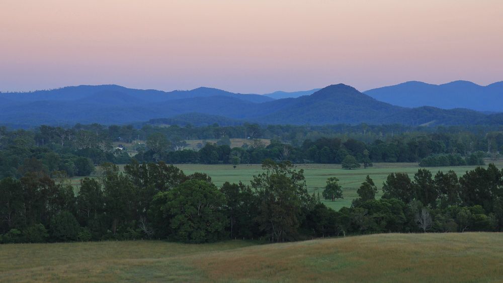 A View of a Field With Mountains in the Background at Sunset — CBS Chainsaw & Brushcutter Specialists - HUSQVARNA in Telegraph Point, NSW