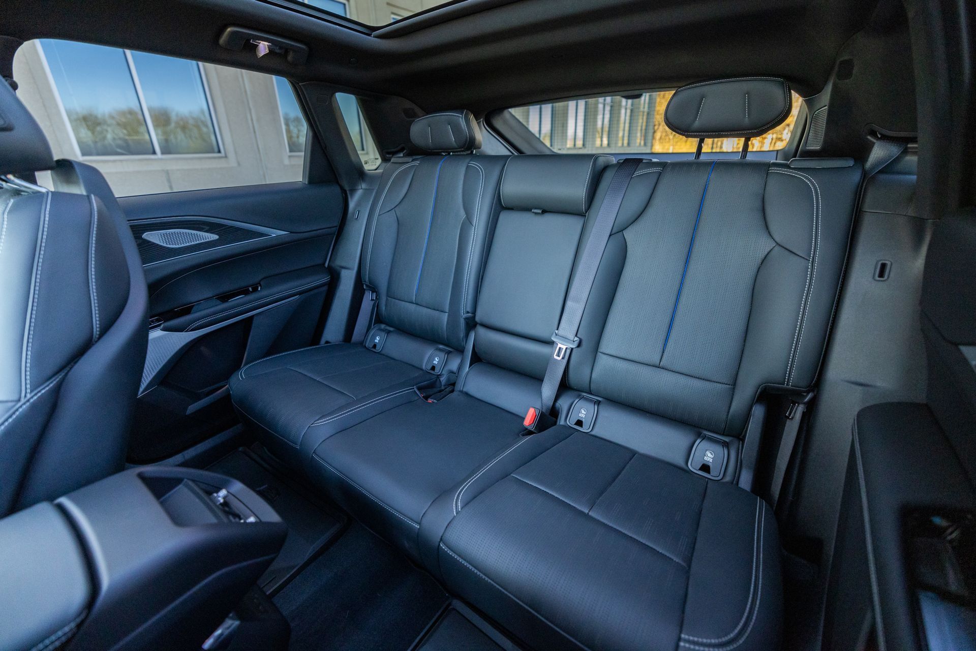 The back seat of a car with a sunroof.
