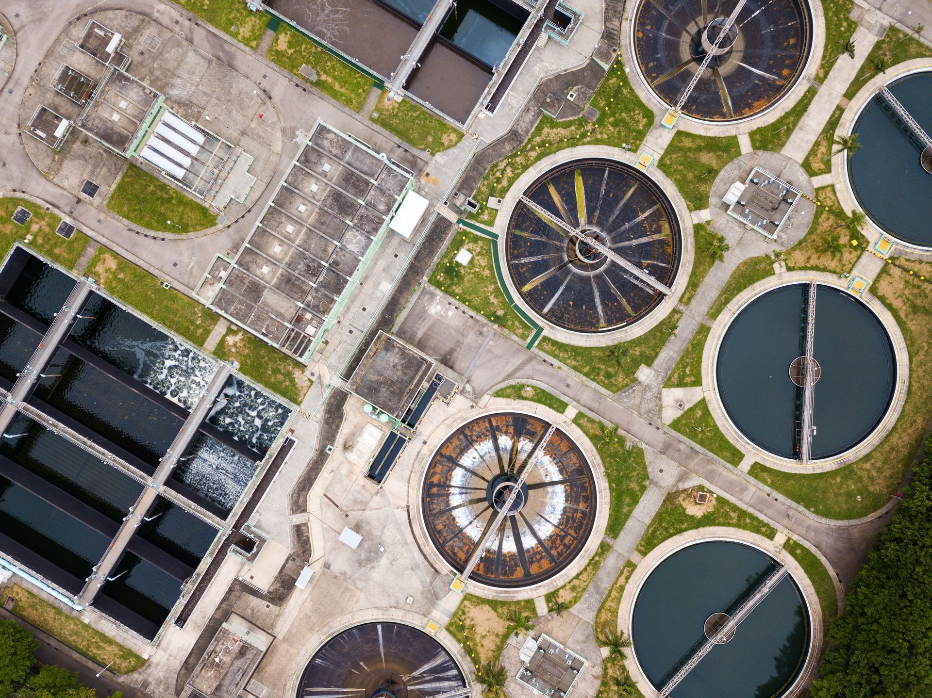 An aerial view of a sewage treatment plant surrounded by trees.