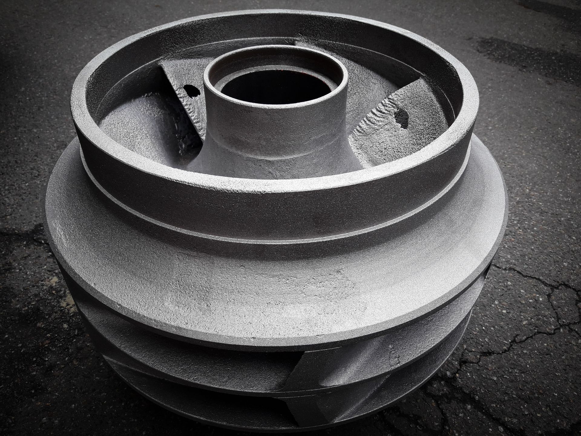 A black and white photo of a metal object with a hole in the middle