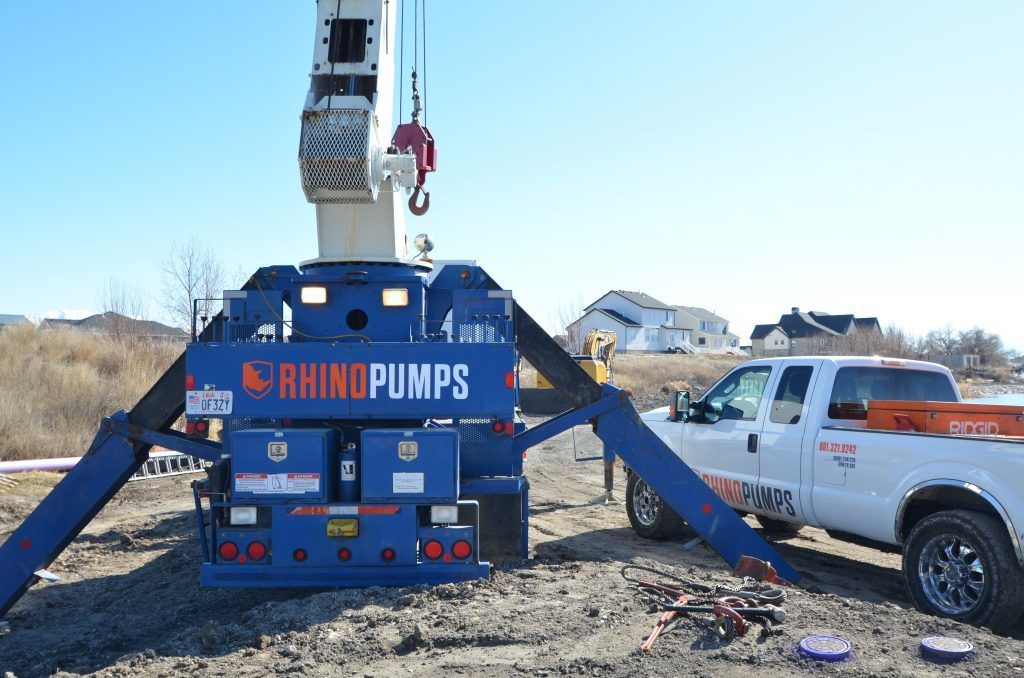 A rhino pumps truck is parked next to a crane