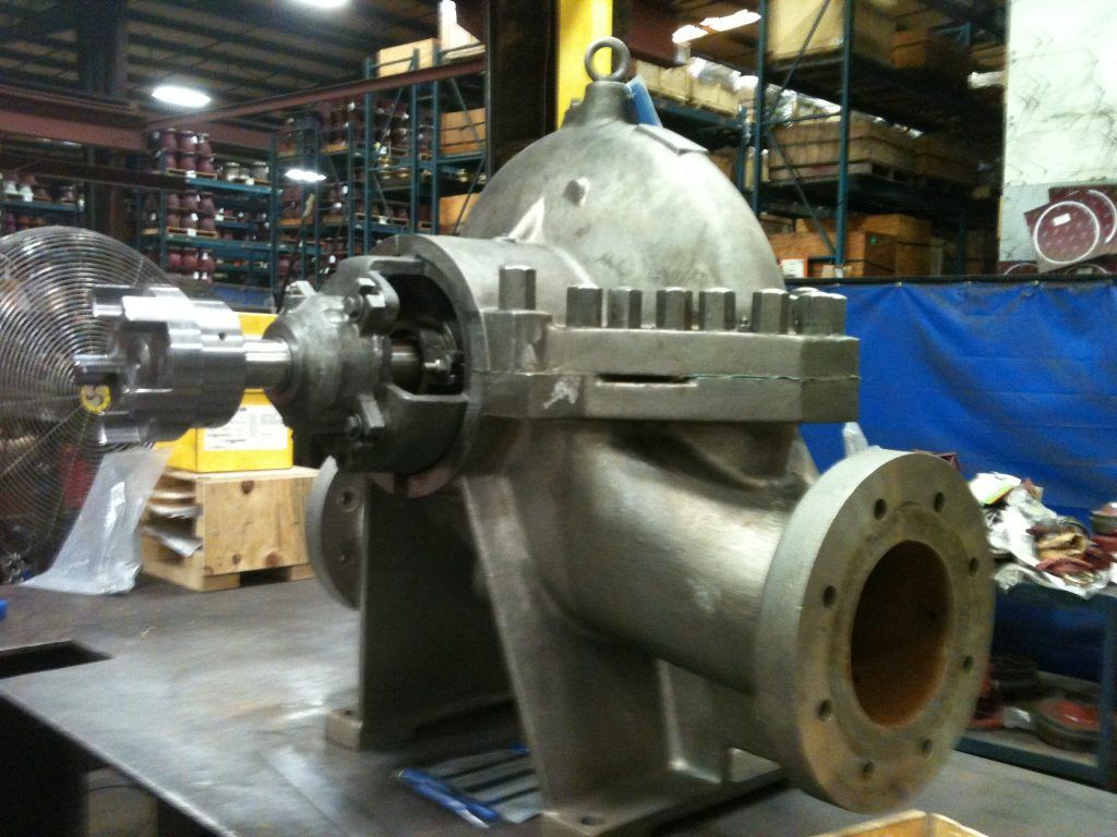 A large metal pump is sitting on a table in a warehouse