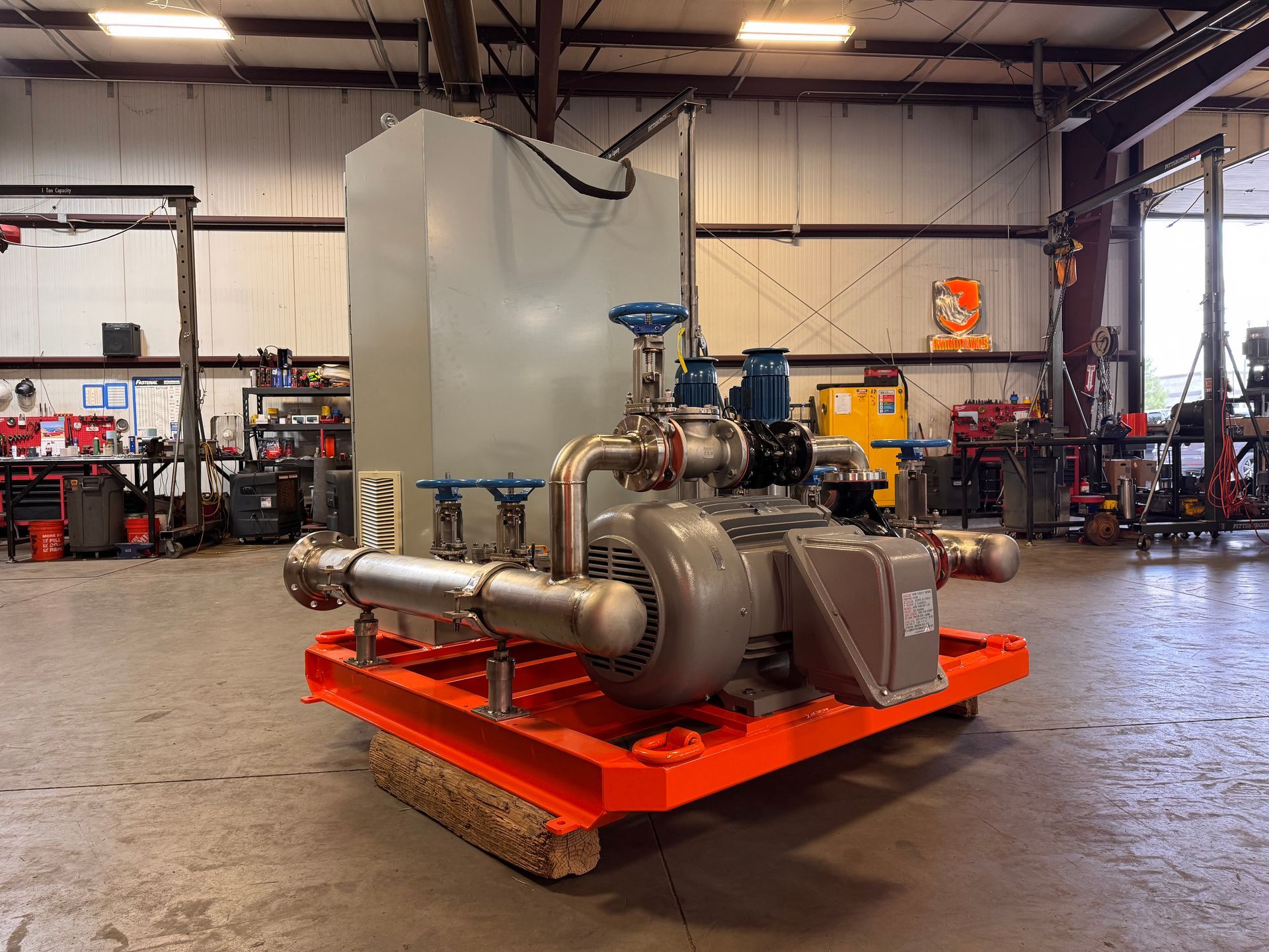Large industrial pump assembly on an orange pallet in a workshop warehouse