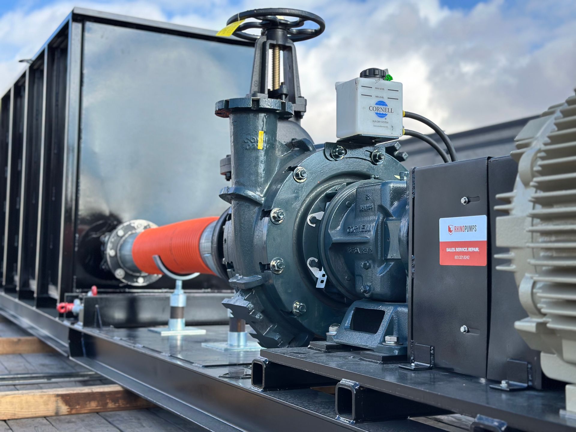 A large pump with a red hose attached to it