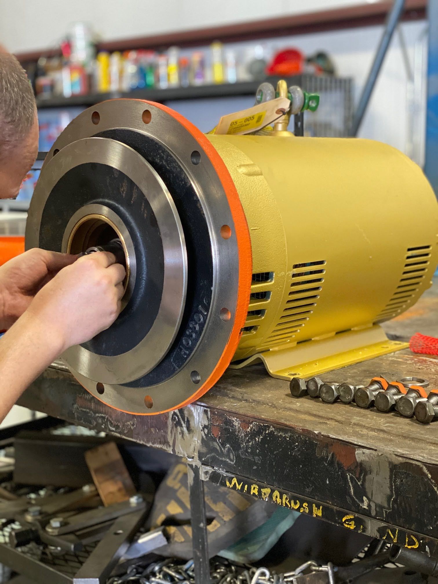 A man is working on a motor on a table.