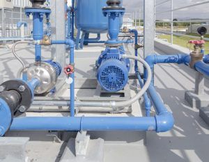 A close up of blue pipes and pumps in a factory.