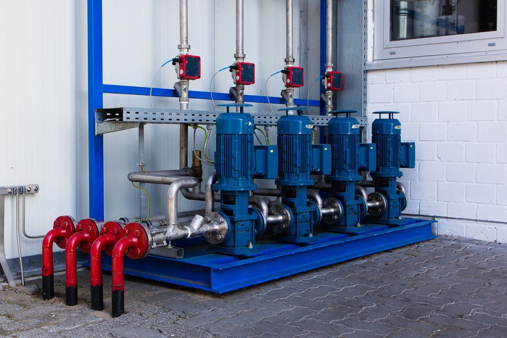 A row of blue pumps are sitting outside of a building.